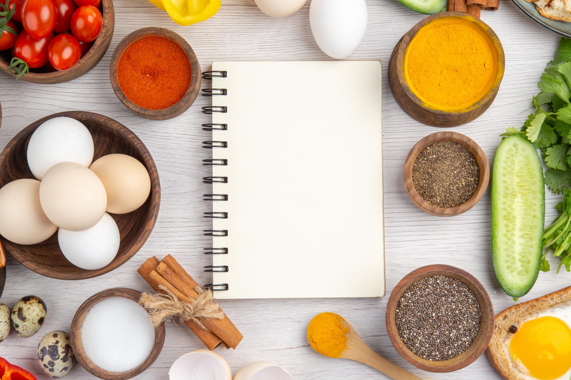 Mesa con ingredientes frescos y cuaderno de recetas